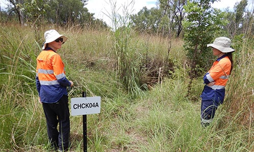 Officers inspect a waste discharge licence compliance point where water is sampled.