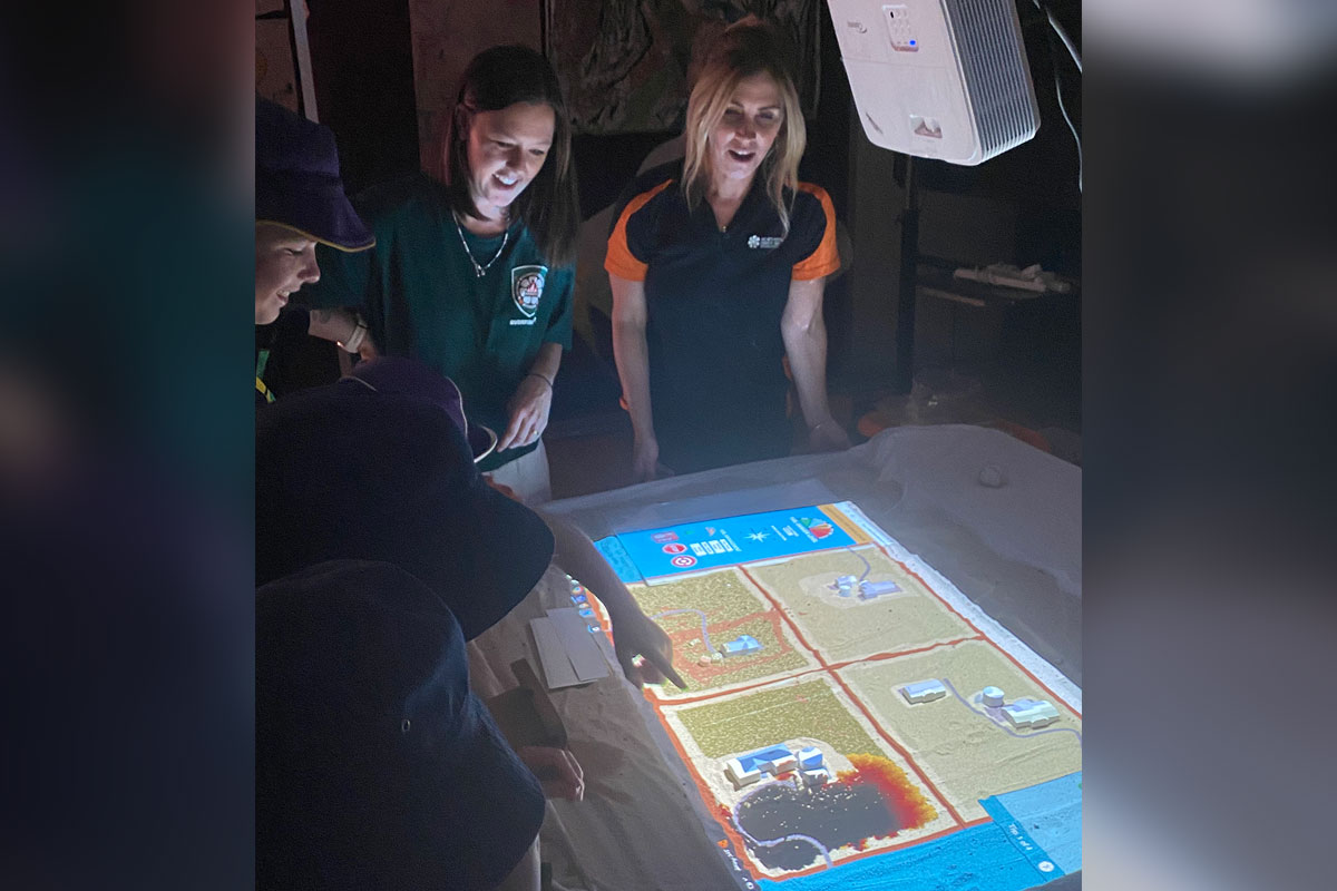 The Gamba Fire Mitigation team show the 4D Gamba Fire table to students.