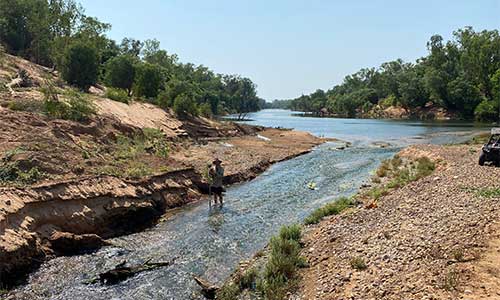 Monitoring officers using a handled ADCP to measure flow in a shallow section of the river not suitable for the larger floating model. Note the All Terrain Vehicle in the photo, the location is too difficult to get to in a four-wheel drive.