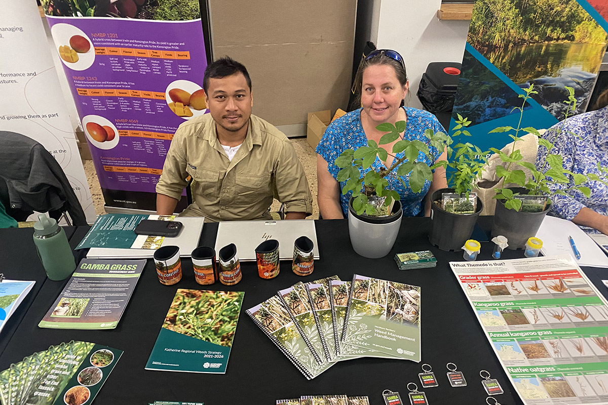 Representatives from the Weeds Management team at their information table during the NT Farmers’ Forage to Farming Forum, showcasing various plant and insect samples, brochures, and resources on weed identification and management strategies.